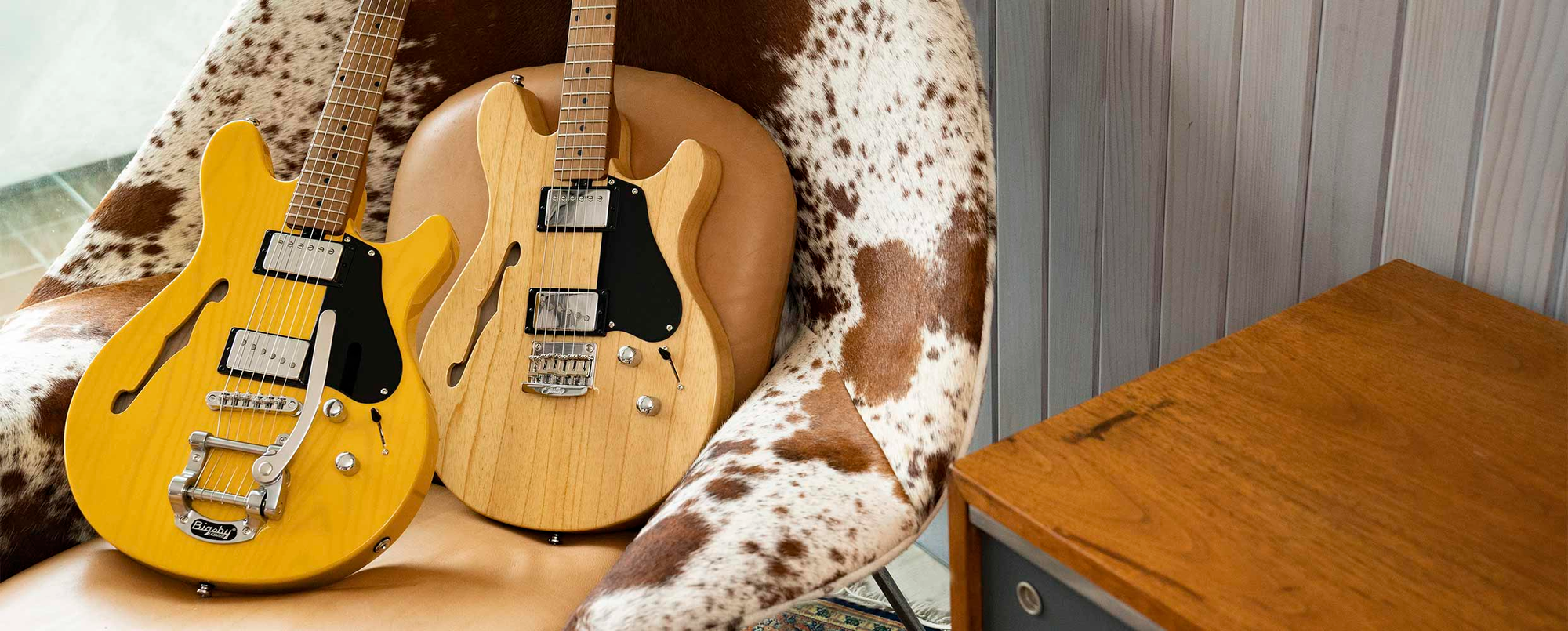 Two chambered valentine guitars on a cowhide chair
