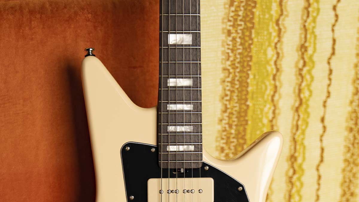 Closeup of the neck of an electric guitar with pearl block inlays