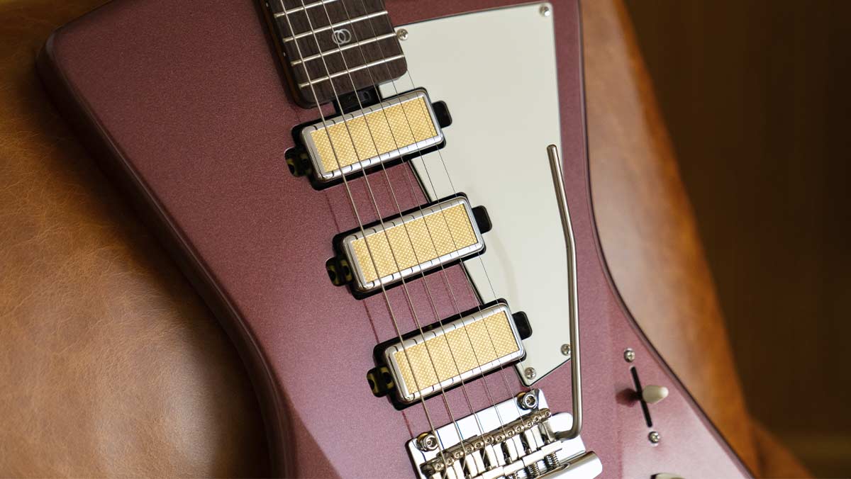 Closeup of burgundy electric guitar with gold foil humbuckers