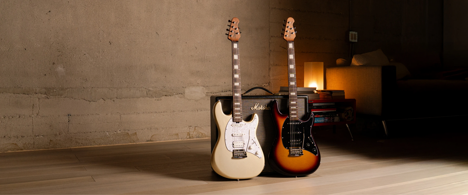 Two cutlass guitars in front of an amp