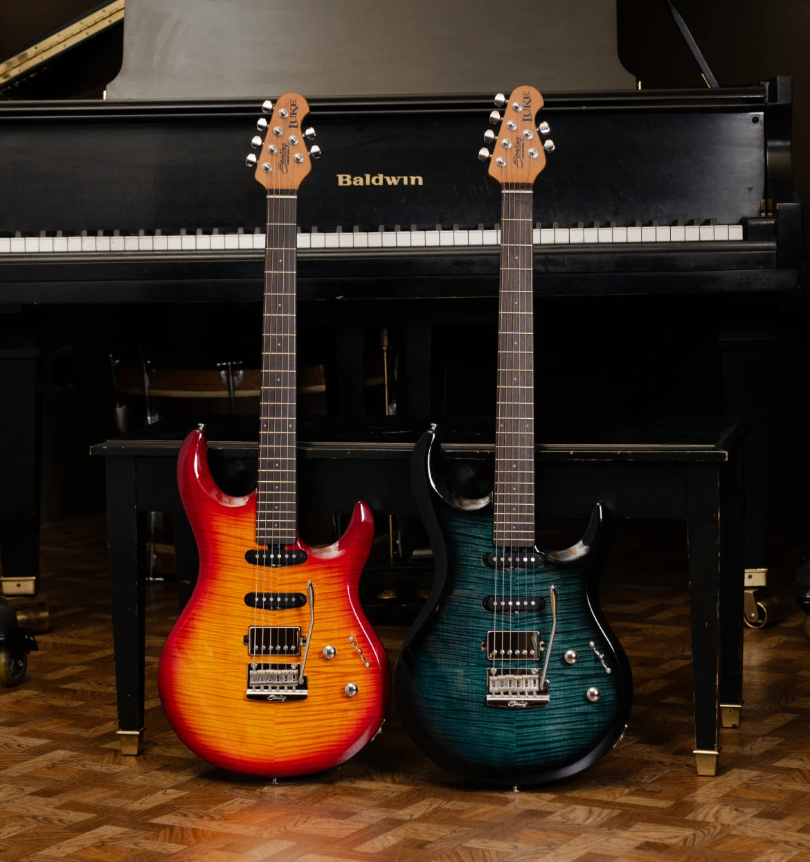 Two luke guitars in front of a piano