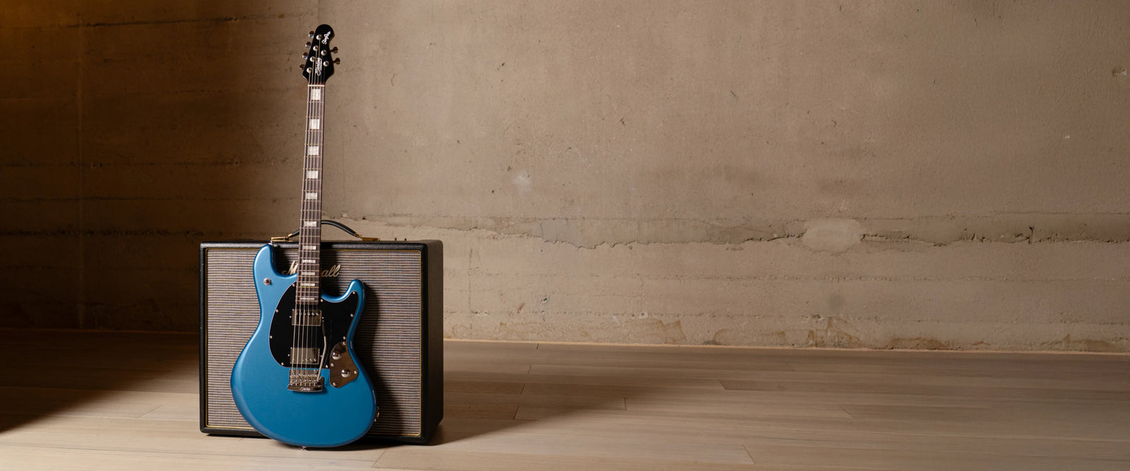 StingRay Baritone in toluca lake blue in front of an amp