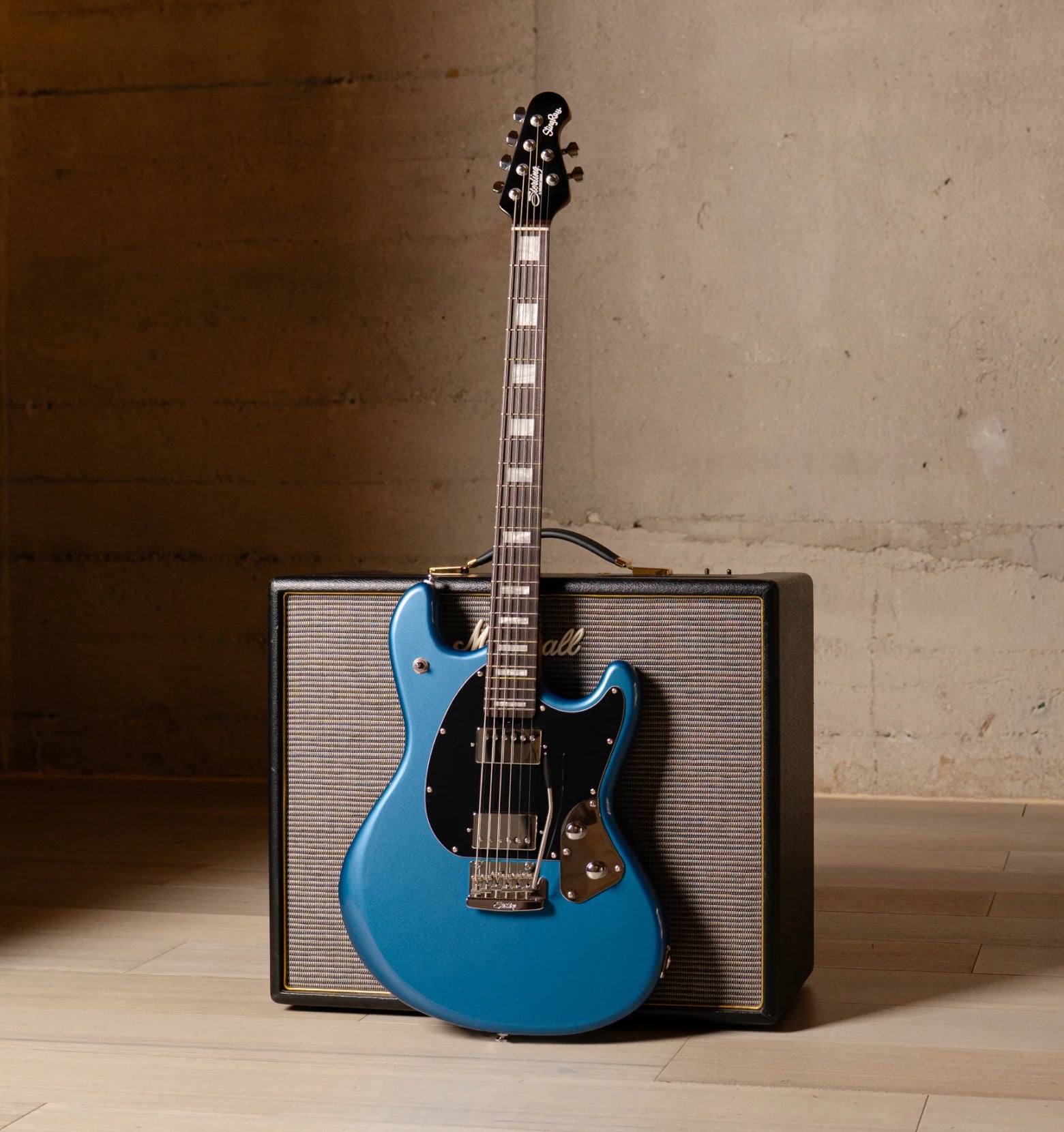 StingRay Baritone in toluca lake blue in front of an amp